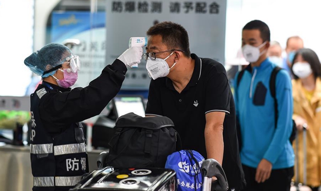 Passengers accept temperature checks at Sanya Phoenix Int'l Airport, Hainan